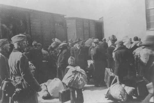 Aleksander Belev, comisionado búlgaro para asuntos judíos (en el centro, con sombrero y de frente a la cámara), supervisa la deportación de los judíos. Skopje, Yugoslavia, marzo de 1943.